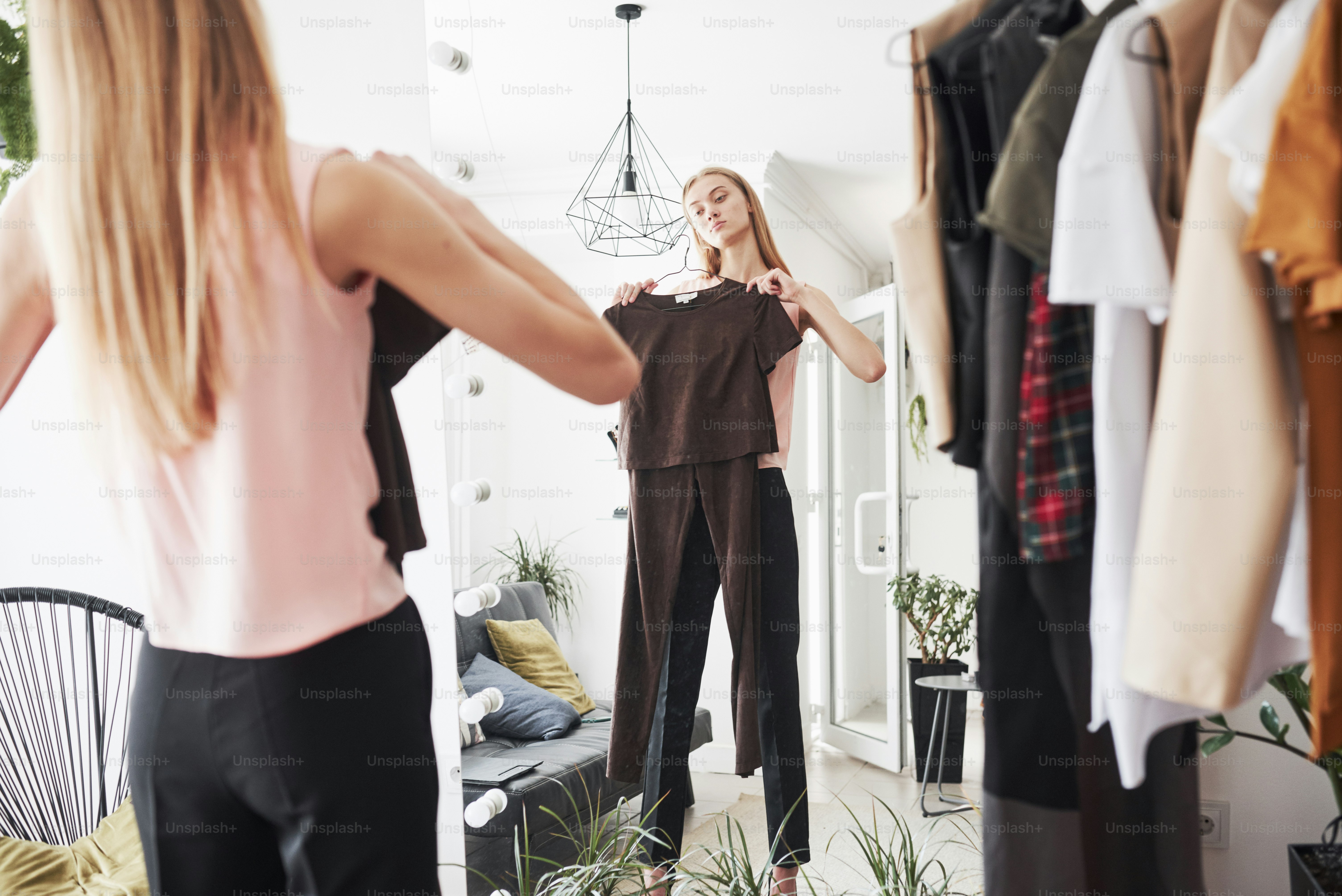 Looks in the mirror. The process of fitting the dress in the studio of hand crafted clothes.