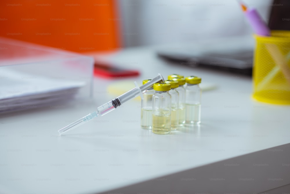 Seringue sur ampoules. Gros plan d’une seringue médicale posée sur des ampoules avec un antibiotique sur la table du médecin