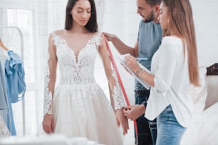 결혼식을 위해 거의 준비되었습니다. 손으로 만든 옷의 스튜디오에서 드레스를 맞추는 과정.