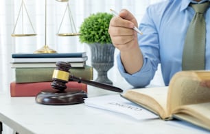 Avocat assis travaillant dans un bureau d’avocat. Ouvrez un livre de conseils juridiques.