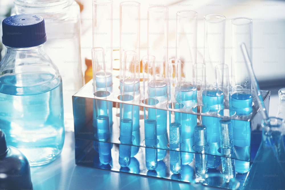La provetta di vetro trabocca nuova soluzione liquida blu di potassio conduce una reazione di analisi prende varie versioni reagenti utilizzando prodotti chimici farmaceutici produzione di cancro