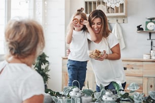 Look at me. Mother, grandmother and daughter having good time in the kitchen.