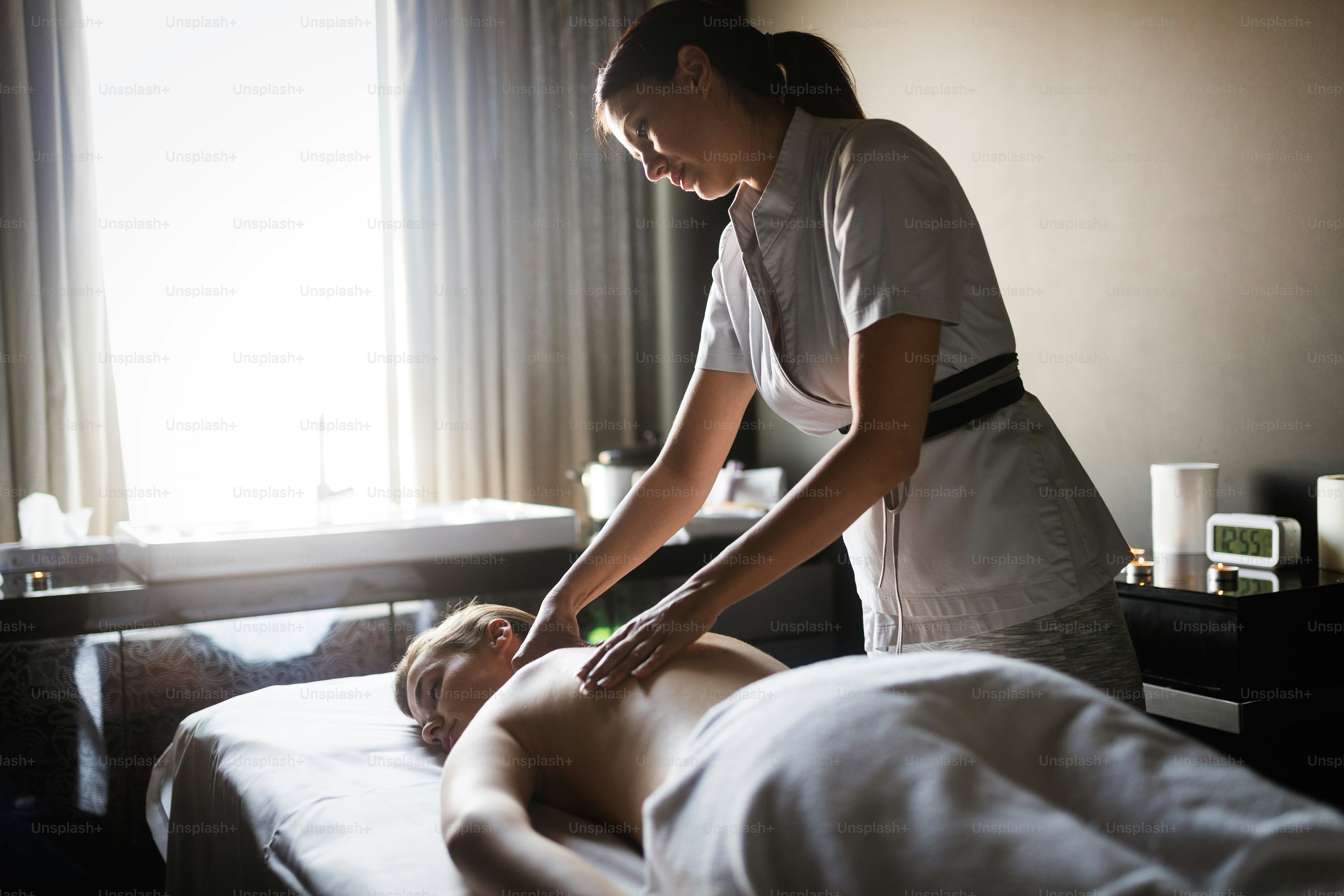 Wanita bahagia santai menerima pijatan di salon