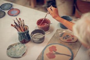 Creative painting. Top view of a clay dish with a flower painting on it