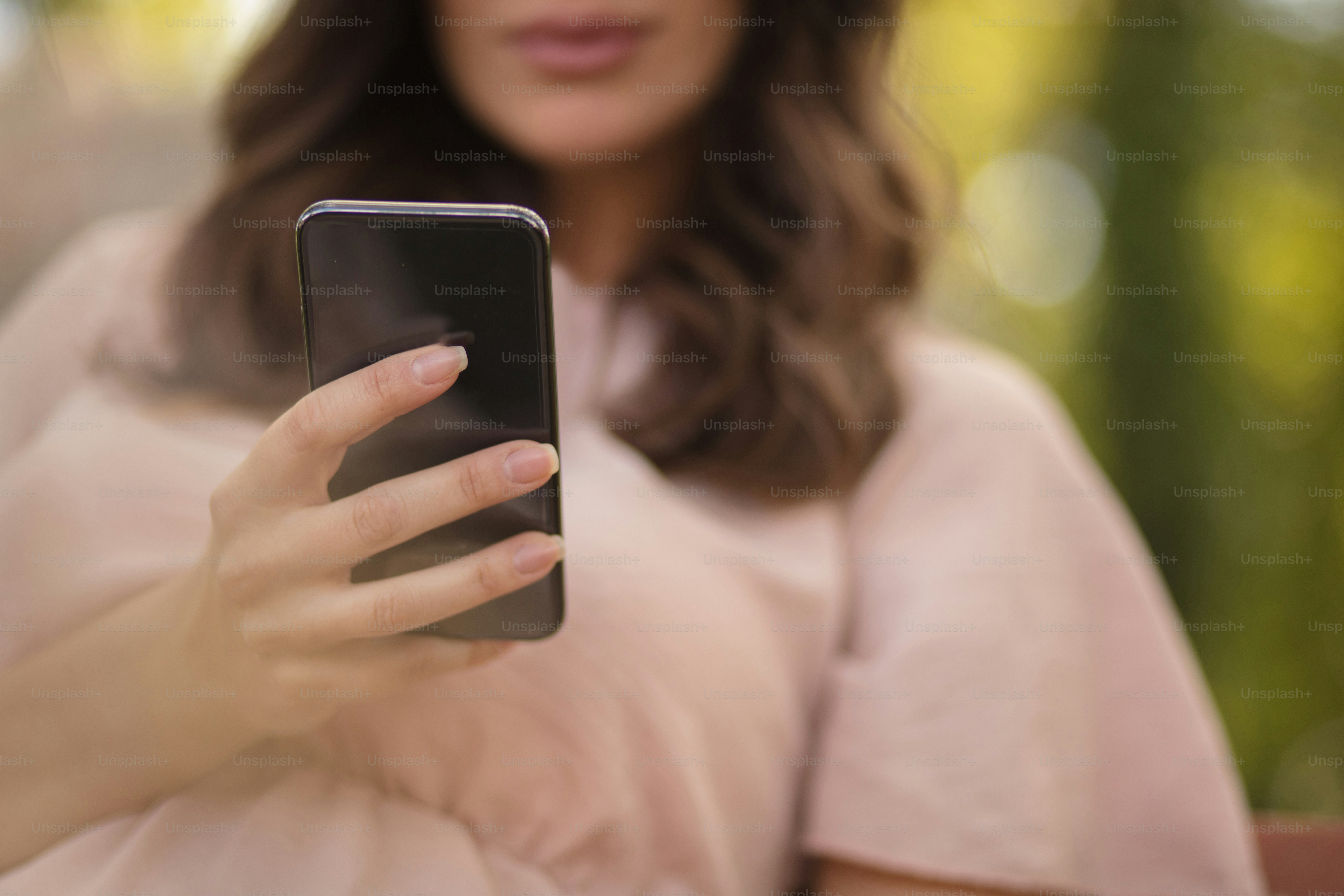 私たちの場所であなたを待っています。スマートフォンを使う自然界の美女。