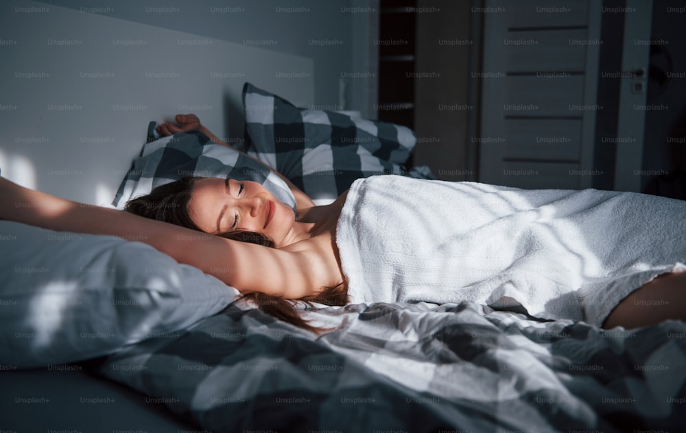 No need to go to the job today. Pretty young woman lying on the bed at morning time in her room.