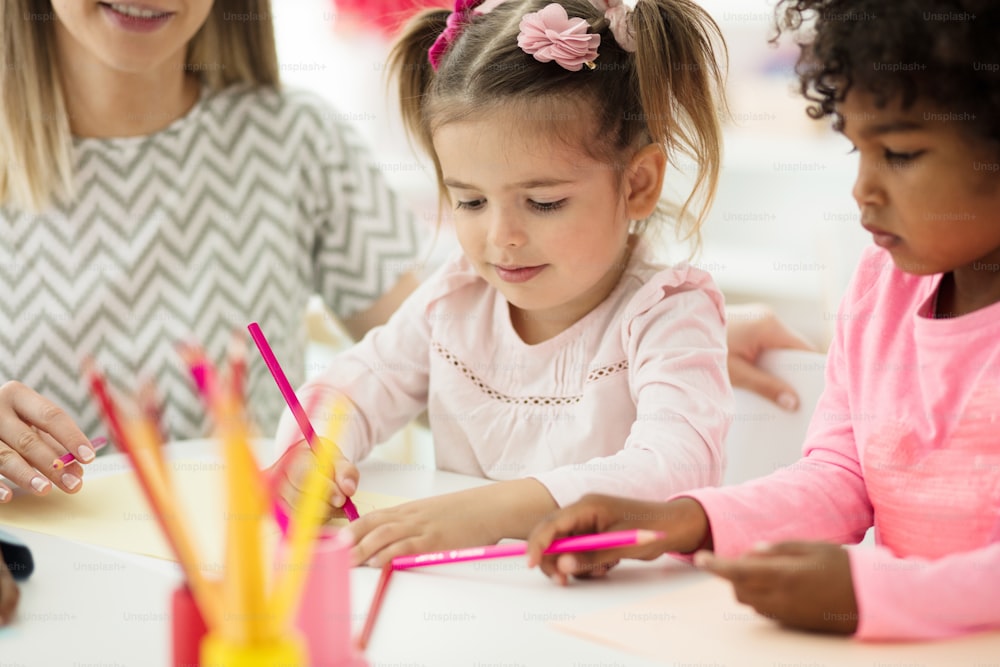 Profesor mostrándoles a dibujar. Niños en preescolar.