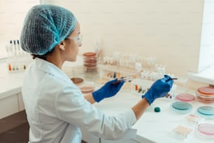 Modern medicine. Intelligent smart woman looking at the test tubes while working in the medical lab