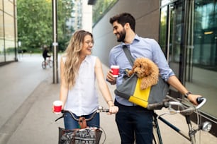 Jovem casal feliz indo para um passeio de bicicleta em um dia ensolarado na cidade