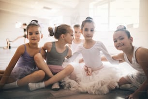 Grupo de crianças em forma que exercitam balé em estúdio juntos
