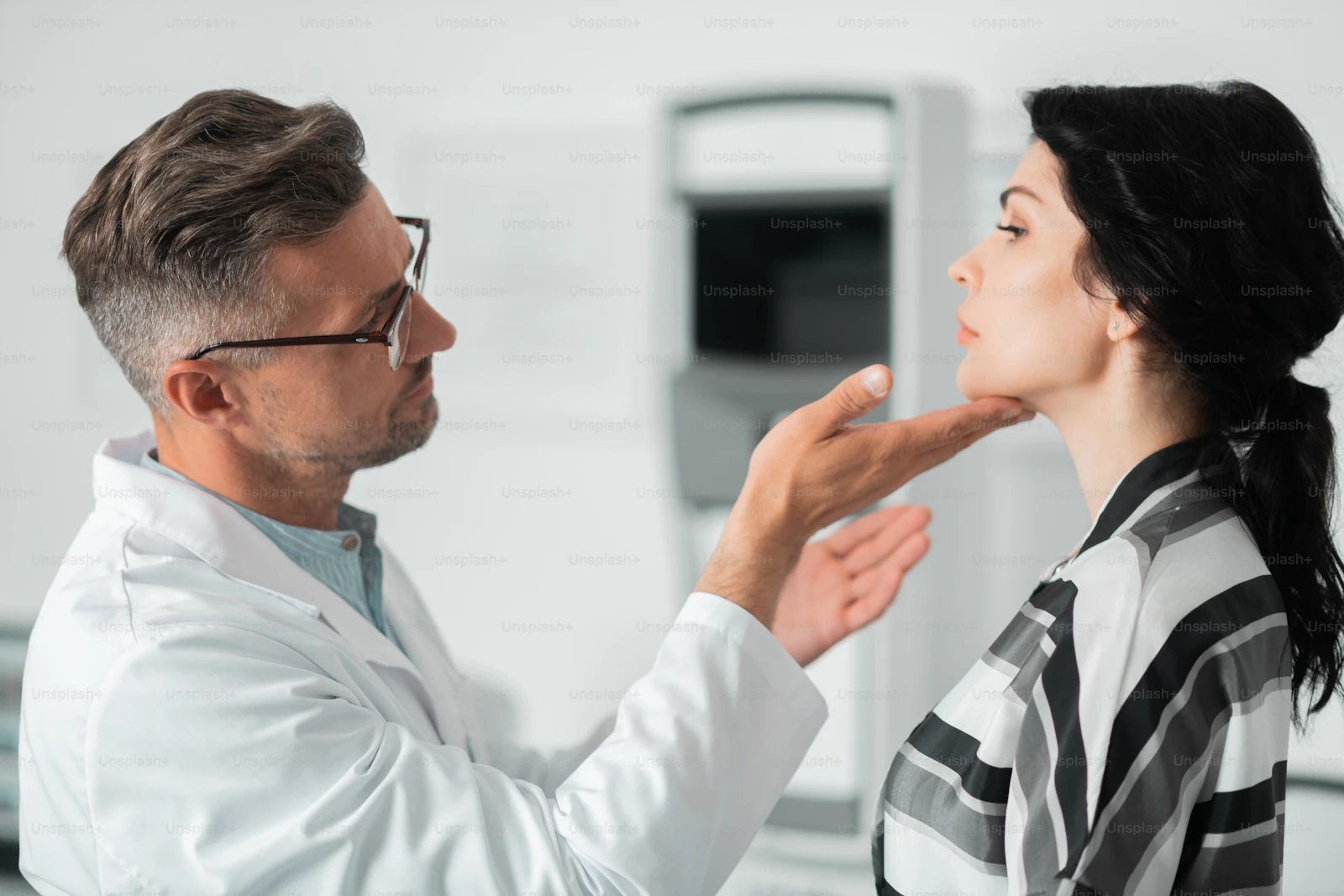 Cosmetic surgeon assessing a patient before a procedure