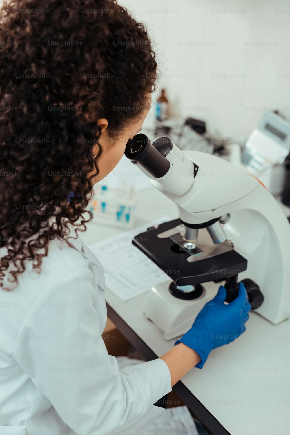 Nuove ricerche scientifiche. Biologa donna intelligente seduta in laboratorio mentre lavora al suo progetto