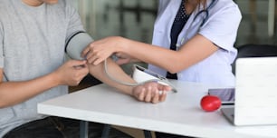 Doctora y paciente midiendo la presión arterial en el consultorio