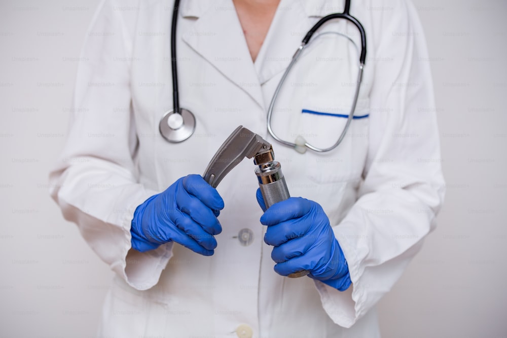 Médecin de la main tenant un laryngoscope, isolé sur fond blanc, espace de copie.