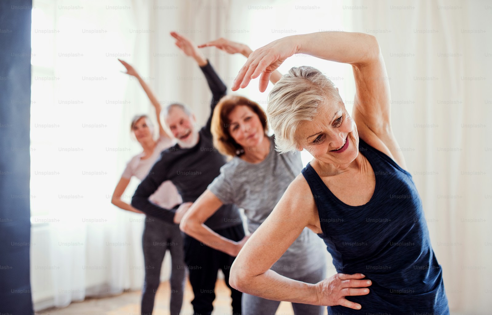 Group of seniors doing gentle standing stretch exercises together