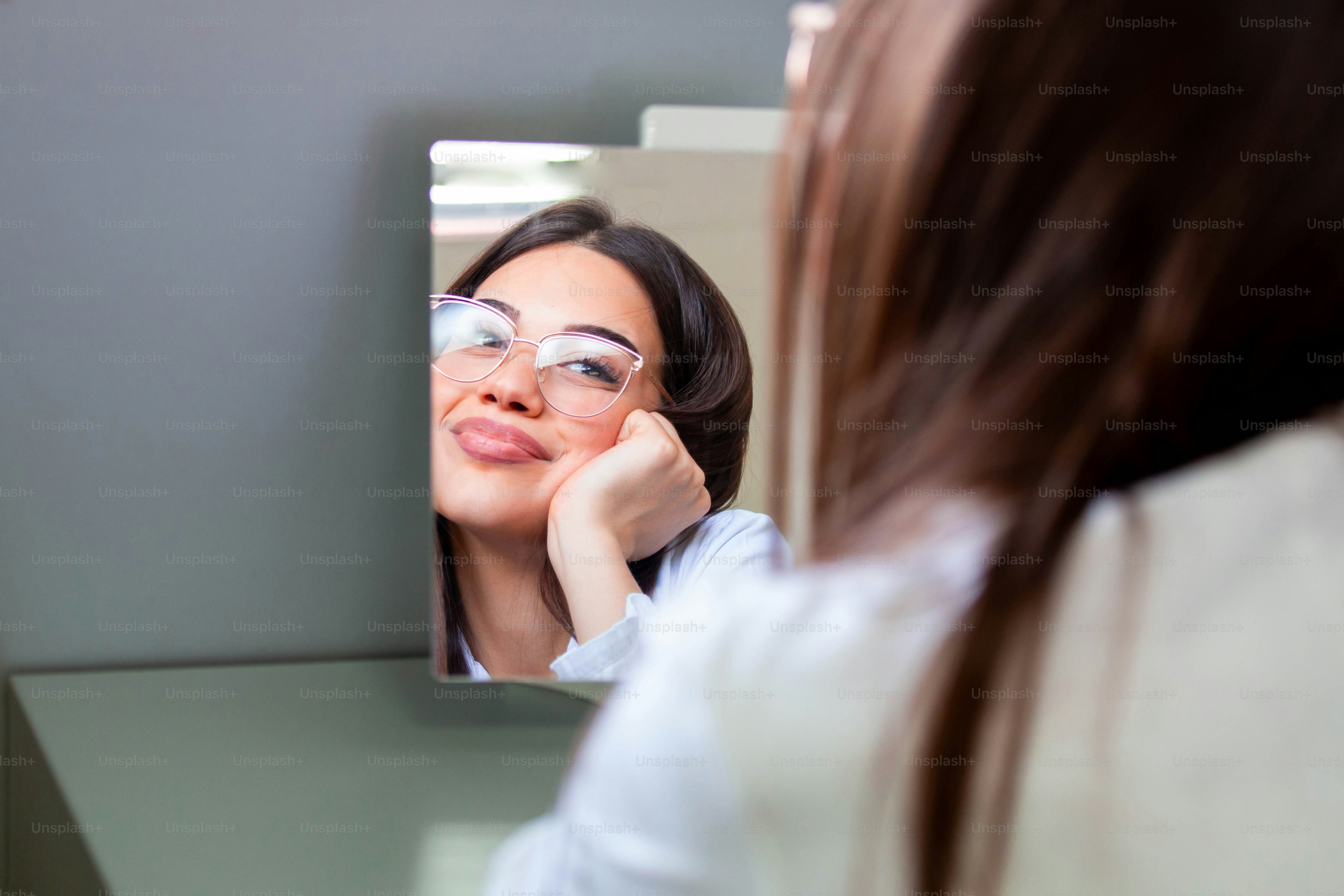 Young girl trying on eyeglasses in front of mirror. Helping to improve vision, saving eye health.