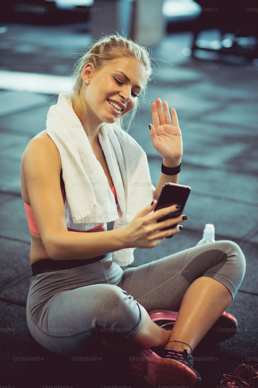 Use a video call pause for your friends. Woman at gym.