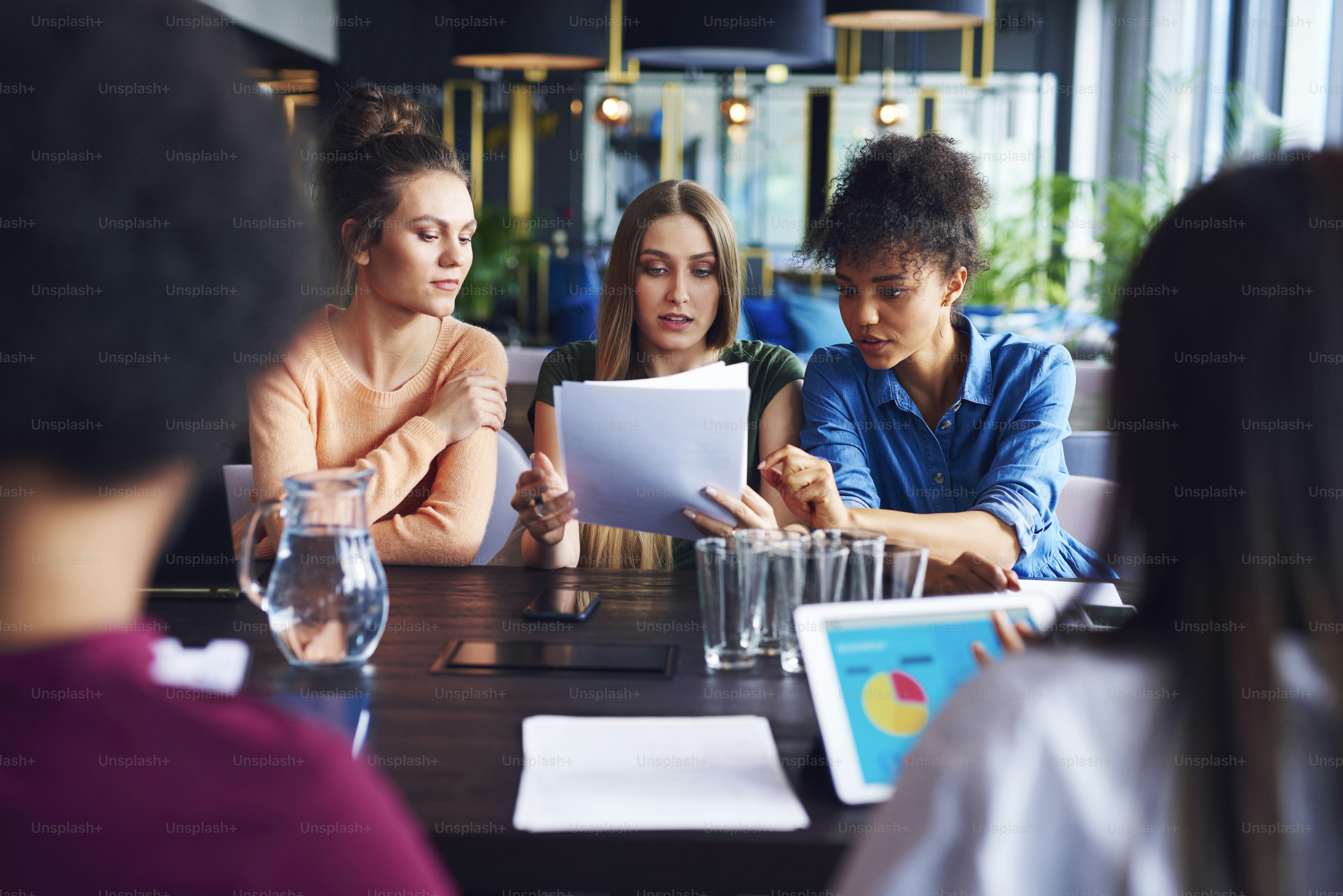Three businesswomen analyzing the documents during business meeting