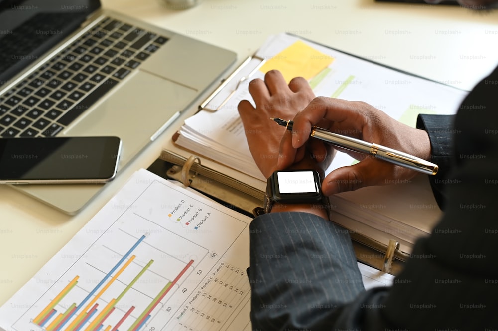 Businessman using smart watch mockup on office table.