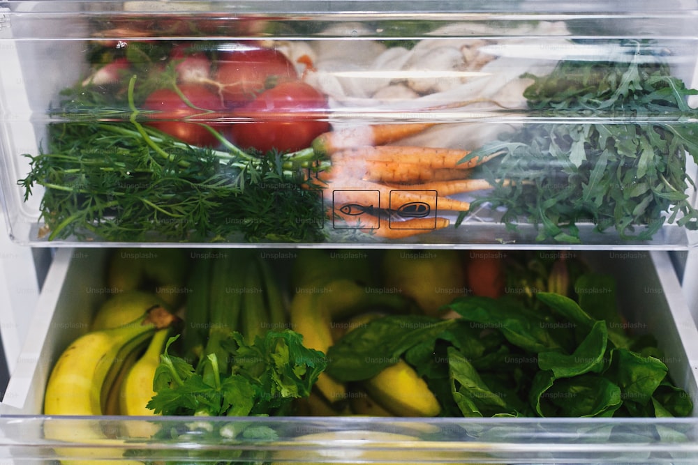 Zero Waste Lebensmittel im Kühlschrank. Frisches Gemüse in geöffneter Schublade im Kühlschrank. Plastikfreie Karotten, Tomaten, Pilze, Bananen, Salat, Sellerie, Äpfel, Zero Waste Shopping. Lieferung von Lebensmitteln