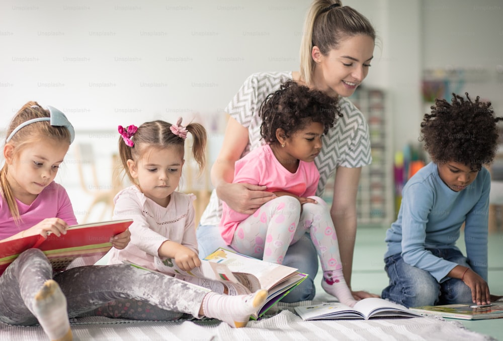 Les encantan los libros. Niños en preescolar leyendo libros.