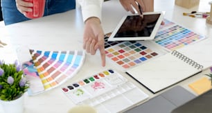 Designers team working paper graphic with color chart and tablet