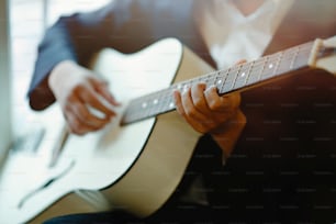 Ausschnittaufnahme eines Mannes, der akustische Gitarre spielt.