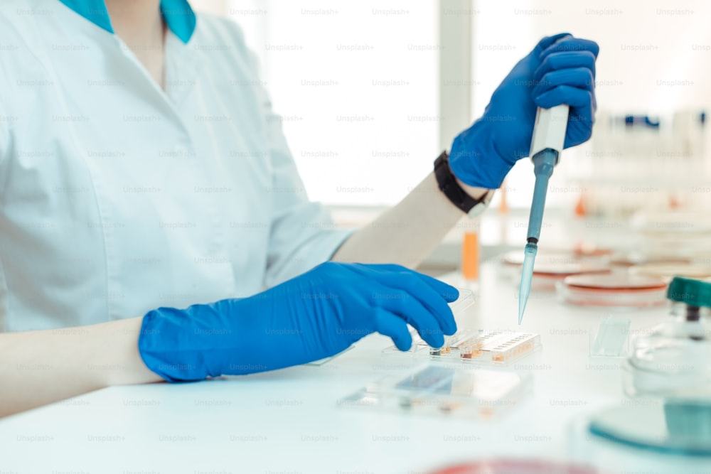 Medical research. Selective focus of a pipette being in the laboratory workers hands while doing the research