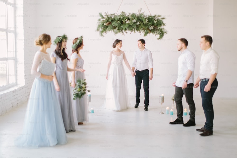 Ceremonia de boda de la novia y el novio de lujo jóvenes con estilo en el estudio de luz blanca