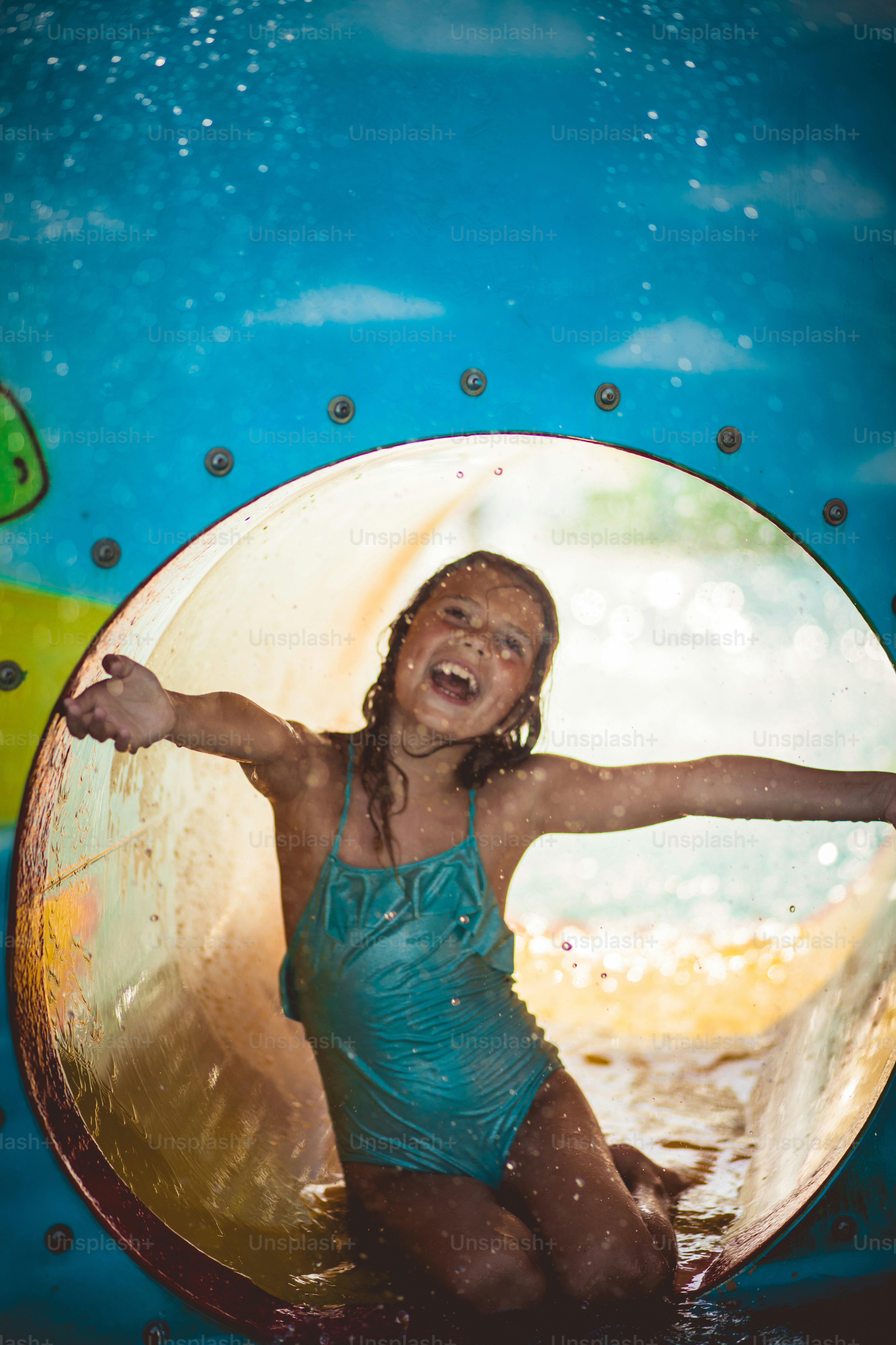 La festa non si ferma mai. Bambino che si diverte sullo slittino della piscina.