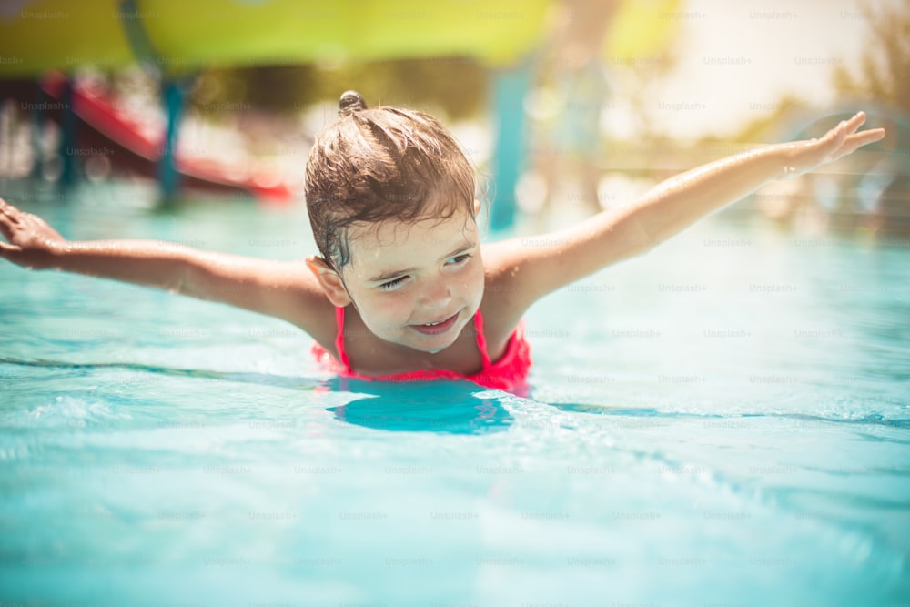 단순한 기쁨. 수영장에서 즐거운 시간을 보내는 아이.
