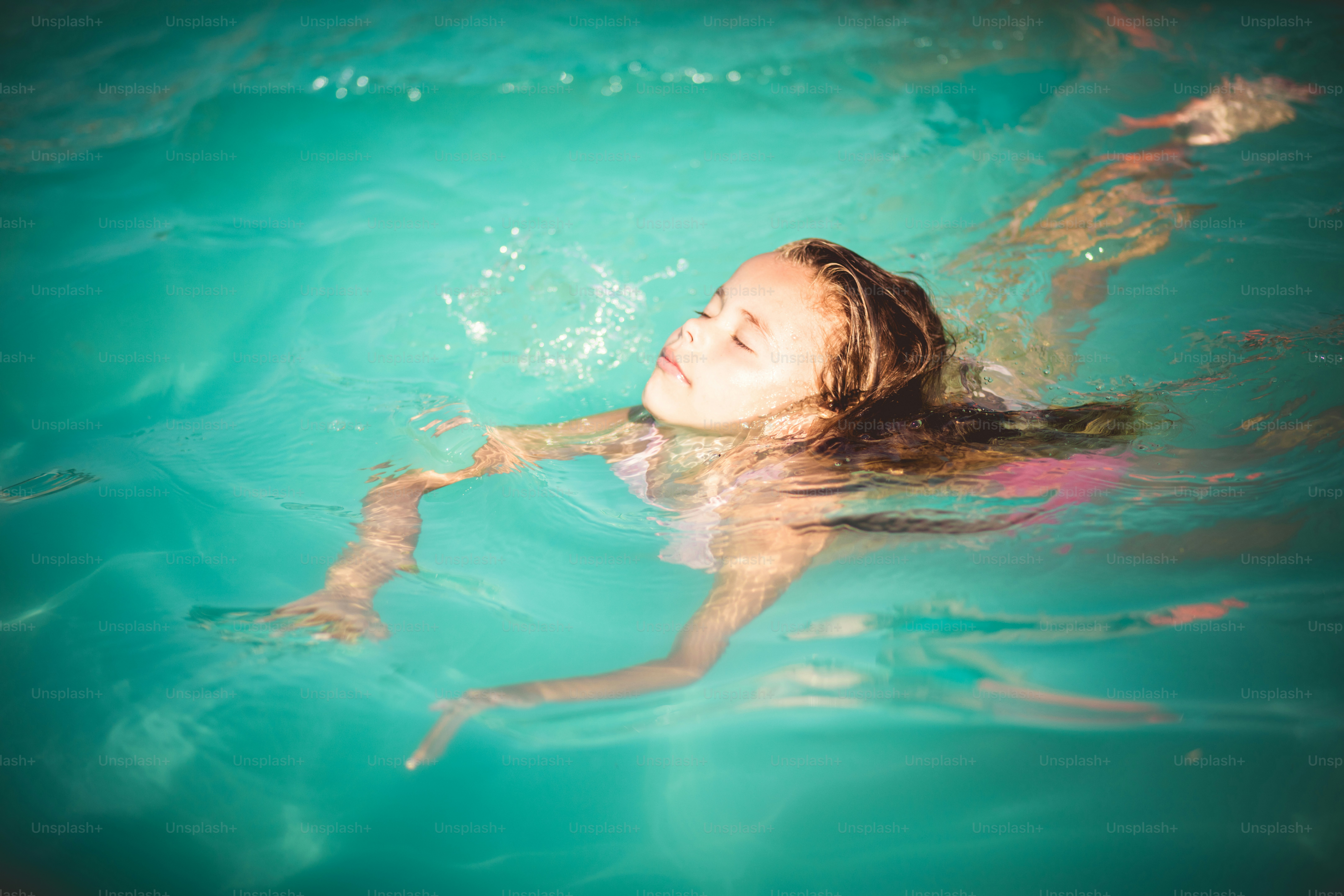 Chilling. Child swimming in water.
