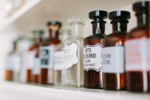 Botellas de vidrio vintage con estilo con sustancias farmacéuticas en el estante de la farmacia antigua.