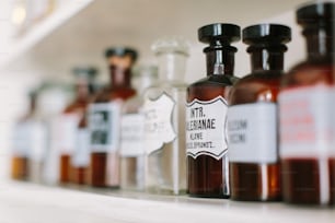 Vintage stylish glass bottles with pharmaceutical substances on the shelf in old pharmacy.