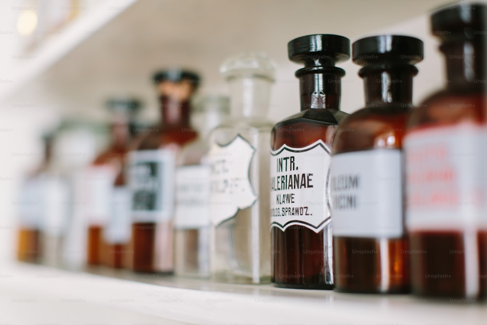 Botellas de vidrio vintage con estilo con sustancias farmacéuticas en el estante de la farmacia antigua.