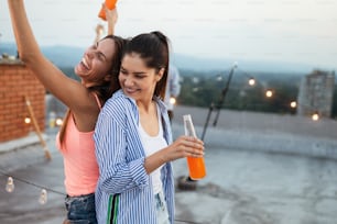 Chicas jóvenes felices divirtiéndose en la fiesta en la azotea