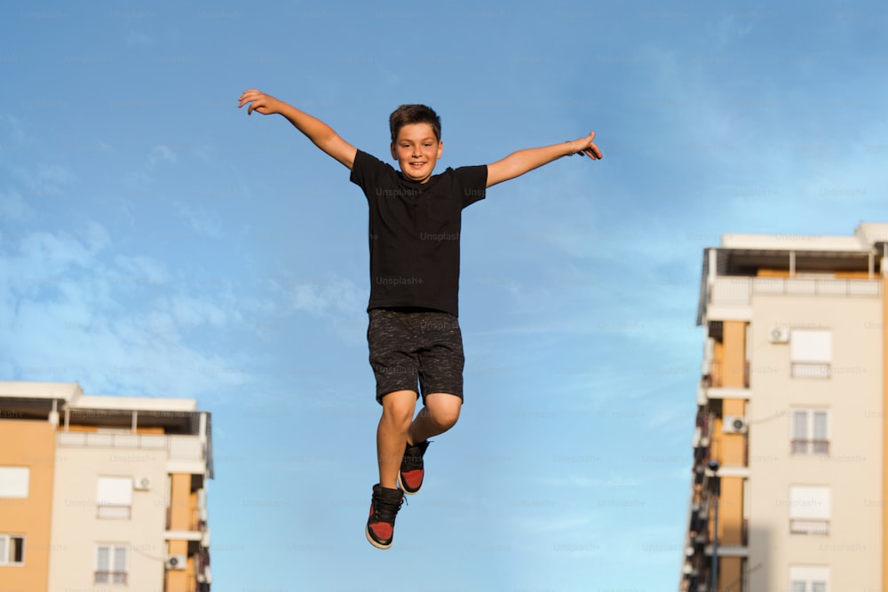 Cute emotional little boy jumping high, i can fly, Kid jumping from happiness