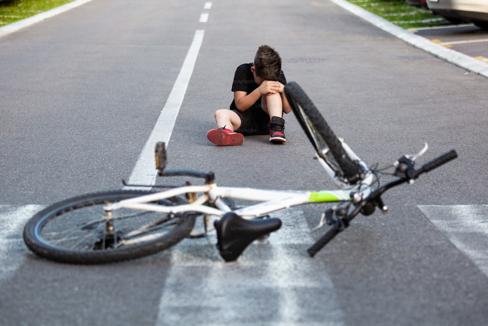 10代の男の子 乗車中に自転車が転倒し、膝を負傷。自転車から落ちて足を痛めた子供