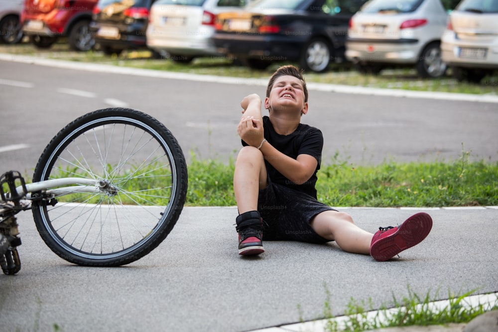 L'infortunio del ragazzo fa male per la caduta della bicicletta, il dolore alle braccia, il dolore per la caduta dalla bicicletta