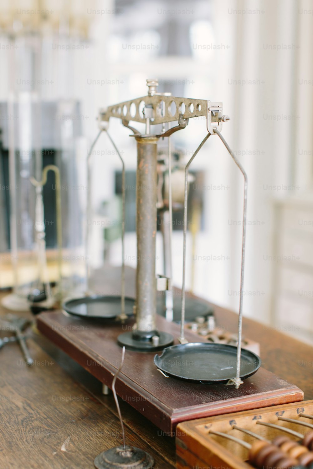 Vintage pharmaceutical scales on an old wooden table with other pharmaceutical supplies.