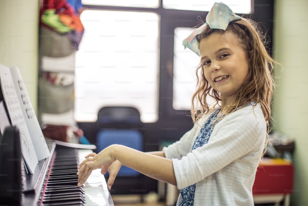 C’est une pianiste en devenir. Petite fille jouant du piano.