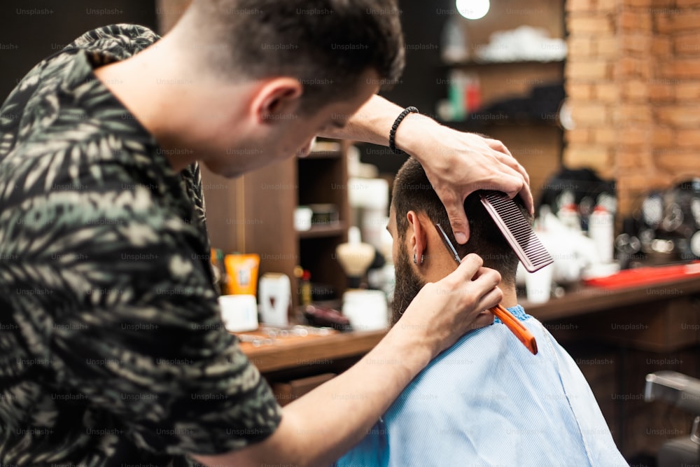 プロの理髪師の手にあるかみそり。まっすぐなカミソリで男の首を剃る美容師