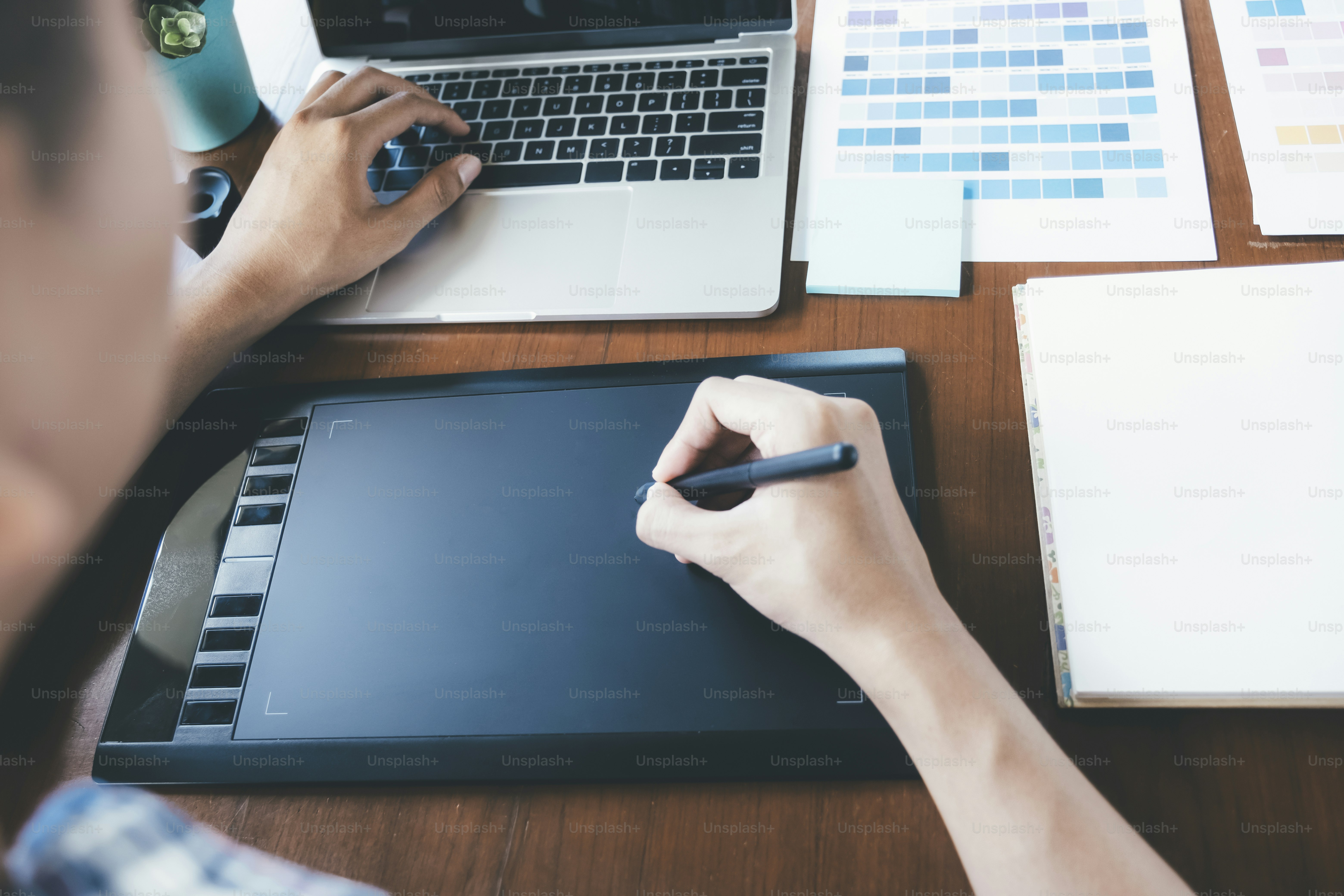 Graphic designer and Photographer working on computer and used graphics tablet.