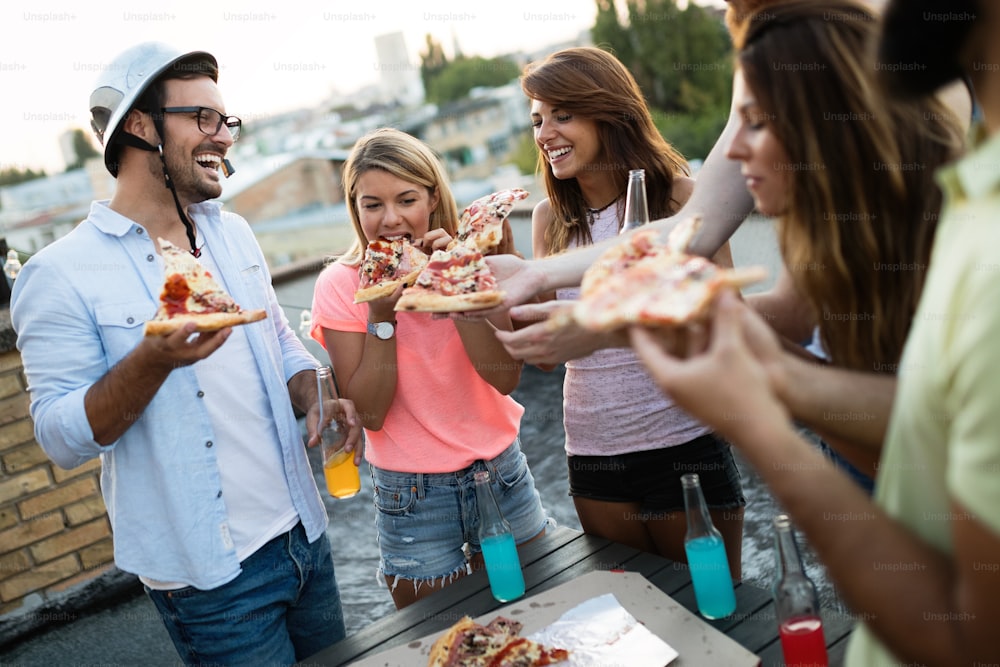 Friends and pizza. Group of young cheerful people eating pizza and having fun