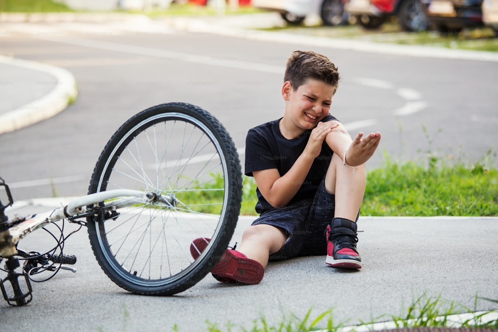 십대 소년 자전거를 타다가 넘어져 팔꿈치 부상이 있습니다. 아이는 자전거에서 떨어진 후 팔을 다쳤습니다. 자전거 타는 법을 배우는 아이