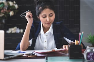 Portrait of smiling pretty young business woman sitting on workplace