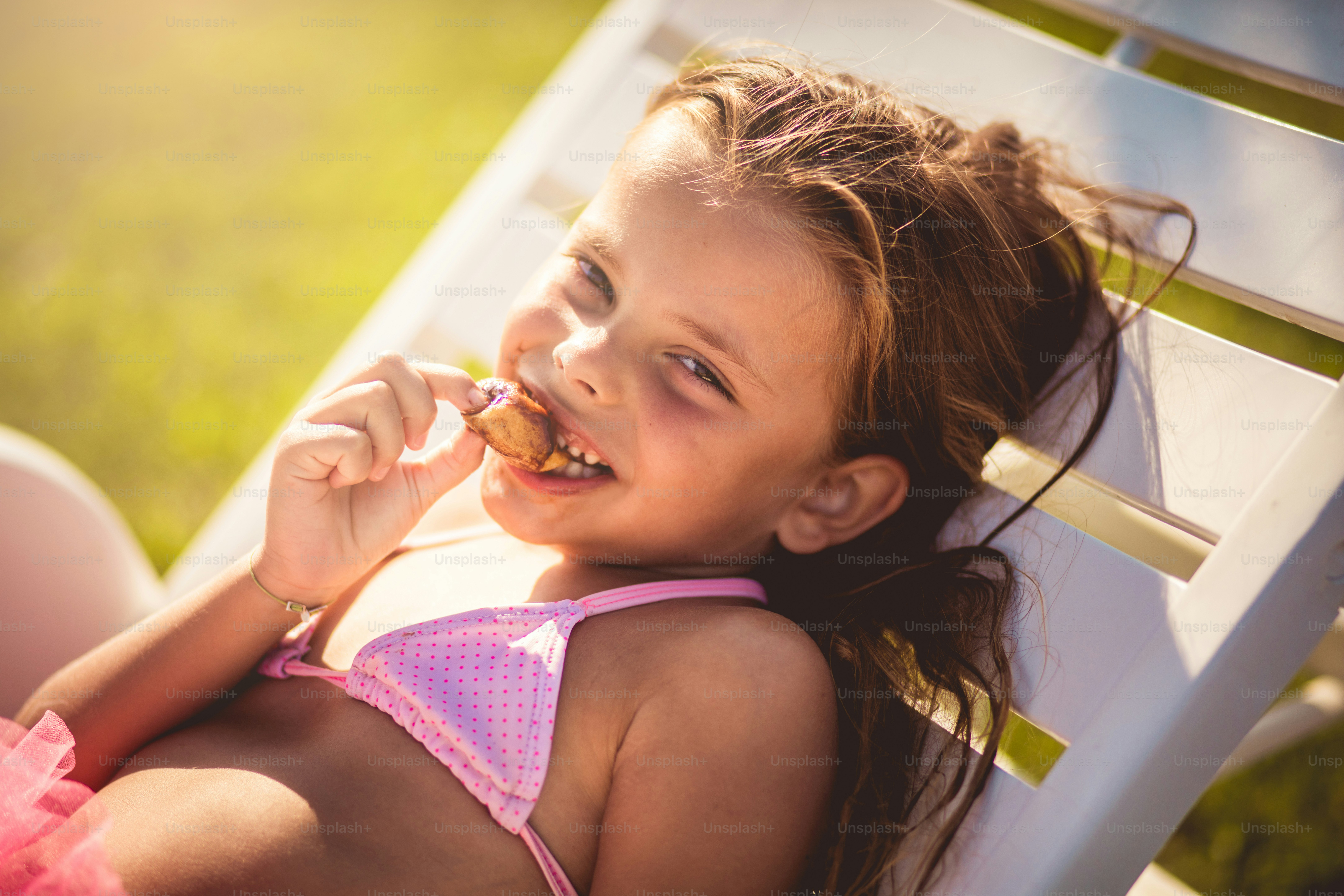Mi godo il sole e le giornate estive. Bambino sulla spiaggia che mangia dessert.