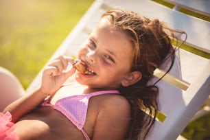I enjoy the sun and the summer days. Child on the beach eating dessert.