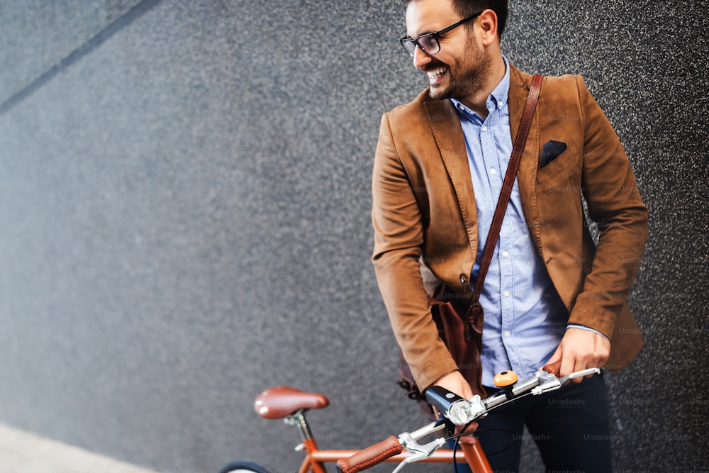 市内の都会の通りで働く自転車を持つ幸せなビジネスマン。交通と健康的なライフスタイルのコンセプト