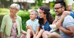 Happy family enjoying picnic in nature with grandparent